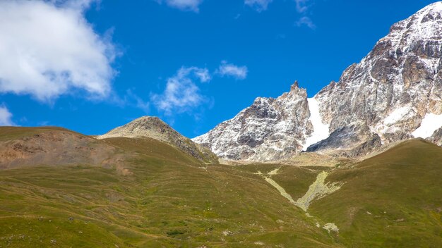 푸른 잔디와 눈 덮인 산의 풍경 조지아 트레킹과 여행