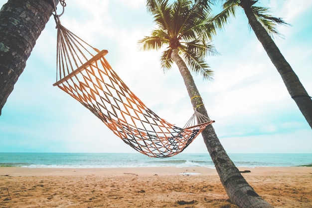 여름에 열 대 해변에서 코코넛 야 자 나무와 해먹의 풍경. 여름 휴가 개념. 빈티지 색조