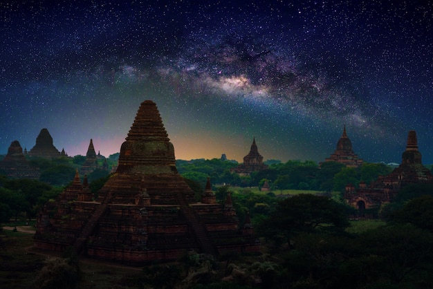 Photo landscape image of ancient pagoda with milky way at sunset in bagan, myanmar.