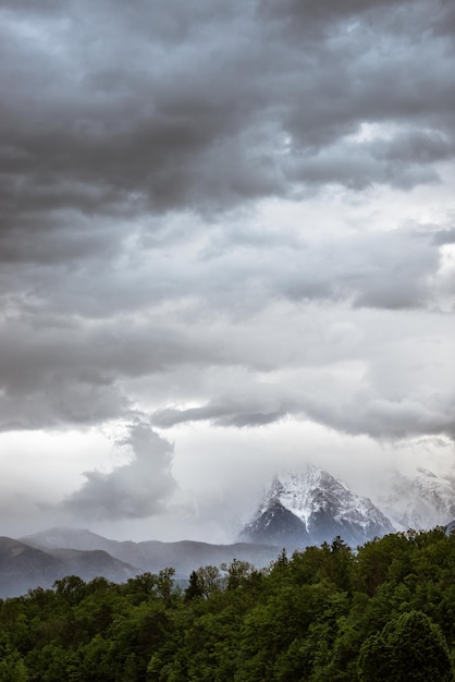 Landscape image of cloudy sky over snowy mountains