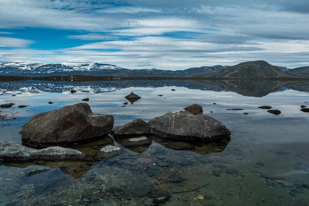 Landscape of lake coastline clean water blue sky mountains on background