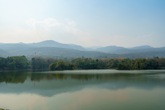 Photo landscape lake views at ang kaew chiang mai university in the pollution fog in nature forest mountain dust air pollution at 2.5 or small particle pm 2.5 microns background with white cloud in thailand