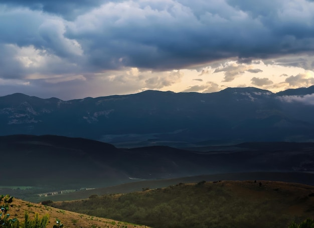 The landscape of mountains under rainy clouds at dusk