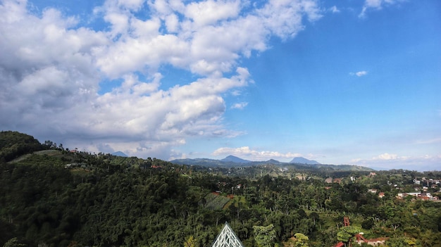Ландшафтный природный пейзаж тропических гор и жилых жилых районов с голубым небом