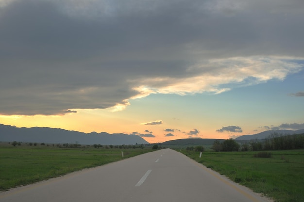 landscape in nature and countryroad adventure with beautiful sunset and dramatic clouds and sky