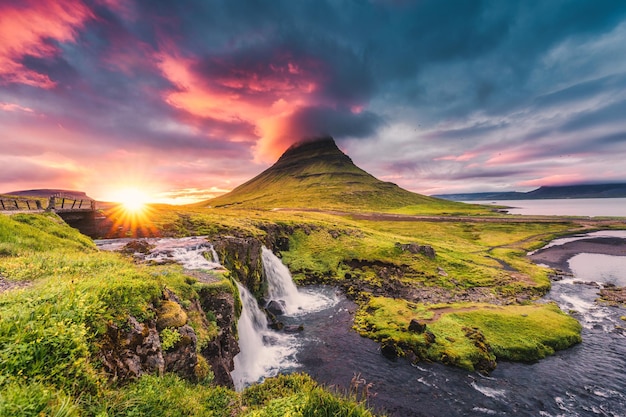 写真 アイスランドの夏の kirkjufellsfoss 滝とカラフルなピレウス雲と kirkjufell 山に沈む夕日の風景