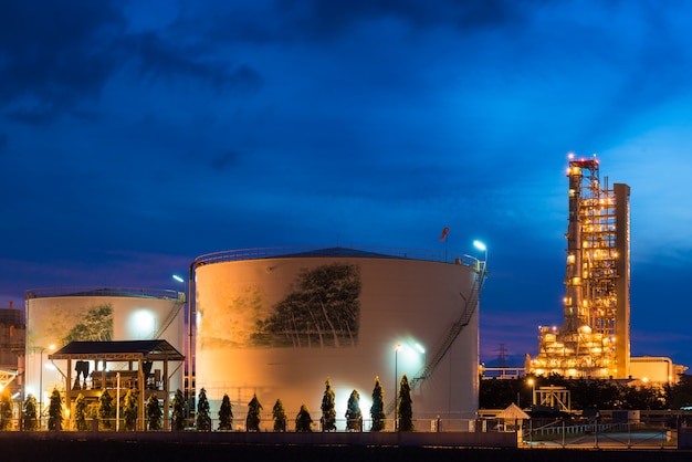 Ландшафт индустрии нефтеперерабатывающего предприятия с баком для хранения масла в ноче.