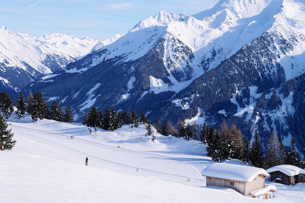 Landscape of Penken ski resort and snowy chalet in Zillertal in Tyrol. Mayrhofen in Austria in winter in Alps. Alpine mountains with snow. Blue sky and white slopes at Zell am Ziller.