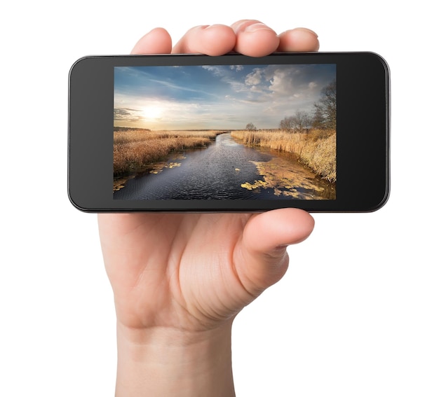 Landscape in a phone in hands isolated on white