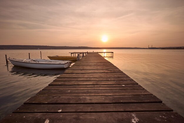 Landscape photo of a jetty and boats on lake at sunset in Varna Bulgaria