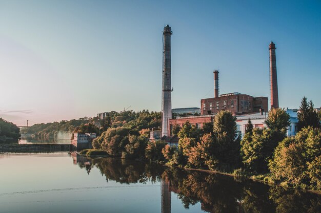 Landscape of river and building with towers dam on the river and bridge on background