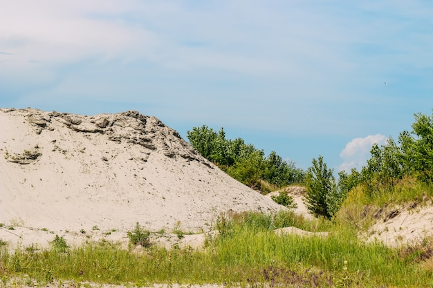 Landscape sand pit with a strip of blue sky with clouds