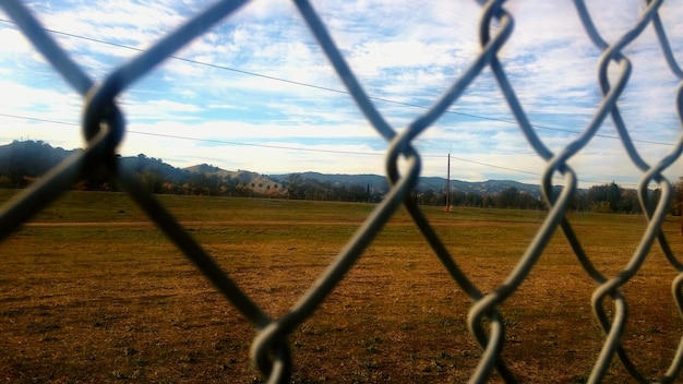 Foto paesaggio visto attraverso una recinzione a catena