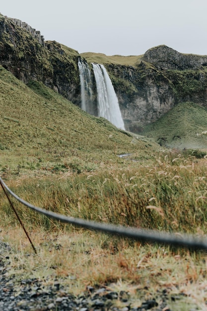 Пейзаж водопада Сельяландсфосс в Исландии в угрюмый день Путешествие на фургоне в стиле дорожного путешествия Концепция поездки в Исландию и северные страны