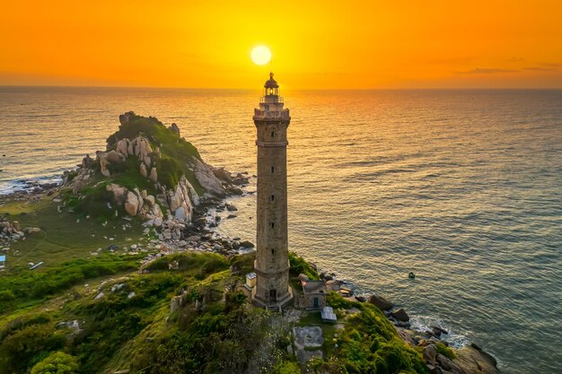 Foto paesaggio di una piccola isola con un antico faro all'alba il cielo è bello e pacifico