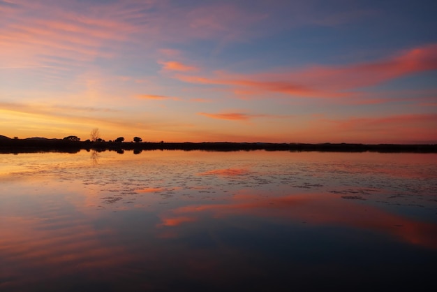 オレンジ色の空と水に映る湖の夕日の風景