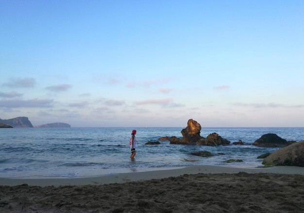 Landscape of a tropical beach with a girl on the water during day