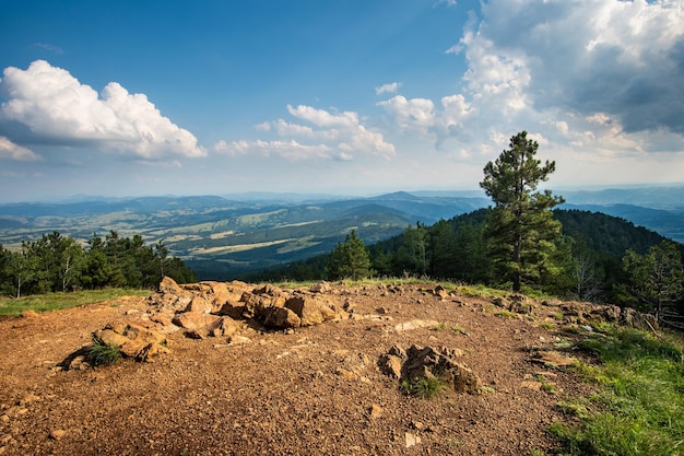 Landscape view from black peak on divcibare mountain in serbia landscape with rocks and conifer trees and mountains in the background