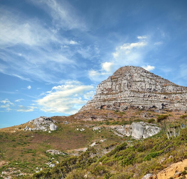 푸른 하늘을 배경으로 구름이 덮인 라이온스 헤드 산의 풍경과 남아프리카 케이프 타운의 복사 공간 인기 있는 관광지와 자연의 거친 거친 하이킹 지형