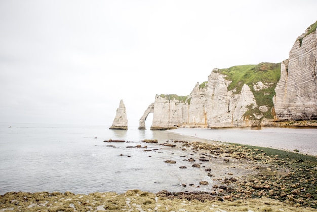 Landscape view on rocky coastline near Etretat town during the cloudy weather