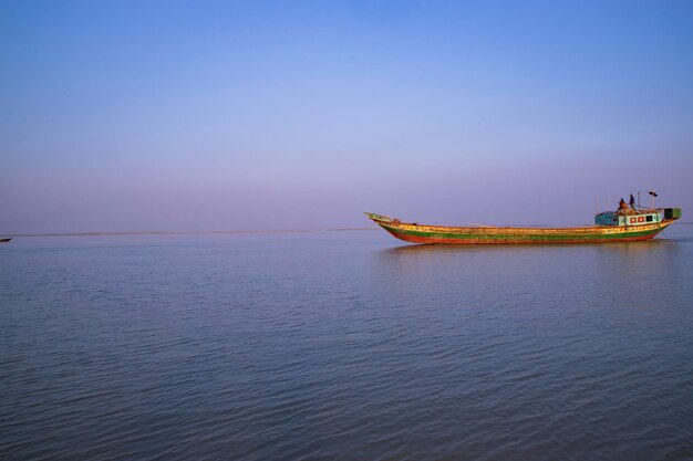 パドマ川バングラデシュの青い空を背景に小さな貨物船の風景を見る