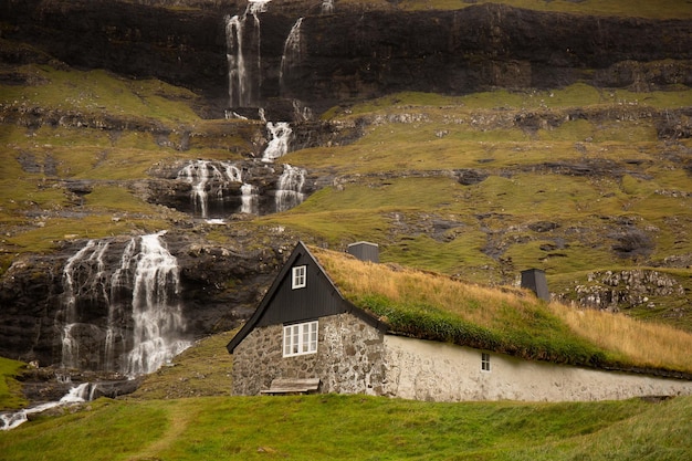 페로 섬(Faroe Island)의 삭순(Saksun) 마을에 있는 잔디 지붕이 있는 전통 석조 목조 주택의 풍경