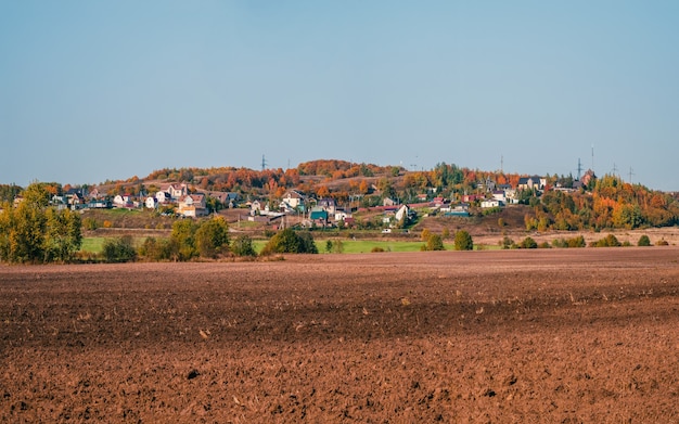 Paesaggio con terreno agricolo con un villaggio sullo sfondo