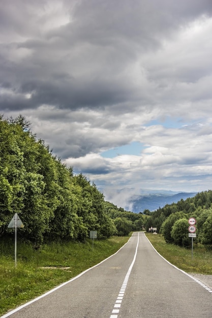 アスファルトの道路と暗い雲のある風景