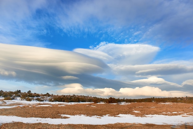 Landscape with beautiful lenticular clouds in the mountains at sunset