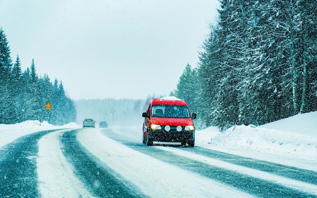 Photo landscape with car in snow road in finland. vacation trip on highway with nature. scenery with winter drive on holiday journey for recreation. motion ride in europe. transport on driveway.