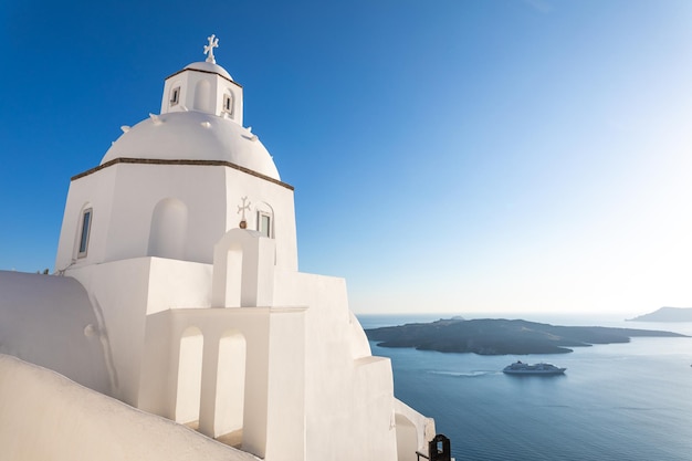 Landscape with greek bell tower, santorini island, greece. beautiful sea view with cruise ship