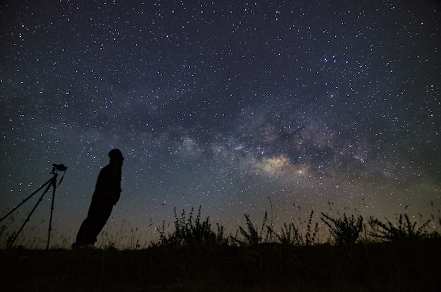 Landscape with Milky Way Night sky with stars and silhouette of a standing happy man