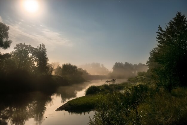 Landscape with moon light at night over river. Fog above water and trees