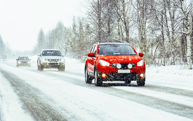 Landscape with red Car in snow road in Finland. Vacation trip on highway with nature. Scenery with Winter drive on Holiday journey for recreation. Motion ride in Europe. Transport on driveway.