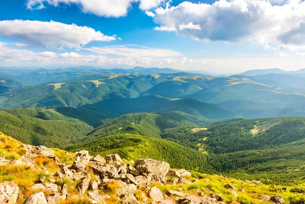 Foto paesaggio con rocce, colline verdi e nuvole bianche su un bel cielo azzurro