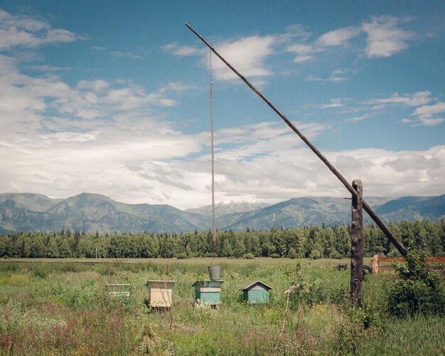 Photo the landscape with shadoof and hives on the mountain background