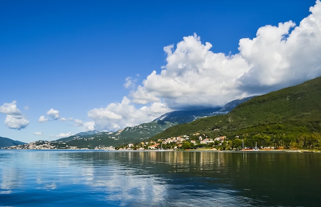 Paesaggio con mare turchese, cielo azzurro con nuvole bianche e la bellissima isola di sveti stefan