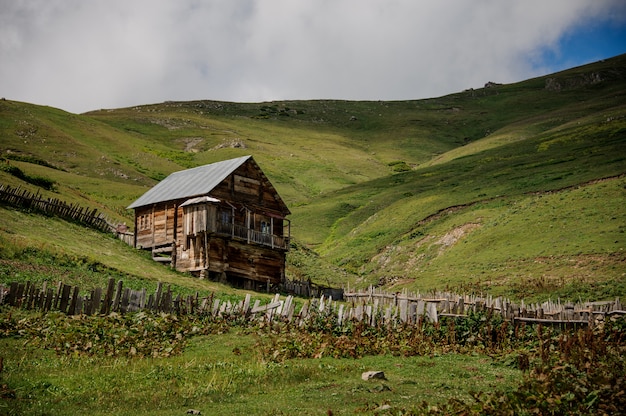 Landscape of the wooden house in the middle of the field