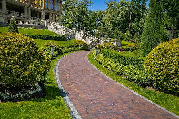 Landscaping in the garden The path in the gardenBeautiful backyard landscape designSome flowers and nicely trimmed bushes on the leveled front yardLandscape formal