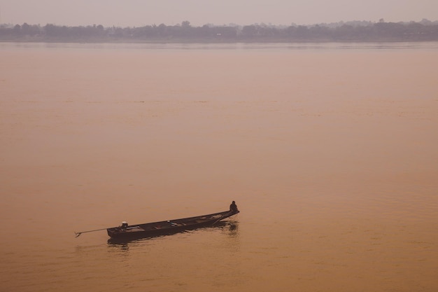 Foto landschap en silhouet met kleine vissersboot op de rivier