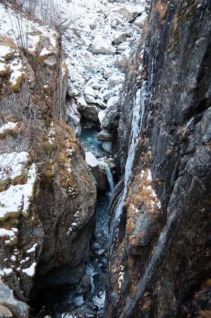 Landschap in de bergen, waterval en naaldbos, herfst, de eerste sneeuw op de hellingen, omgevallen bomen en struiken