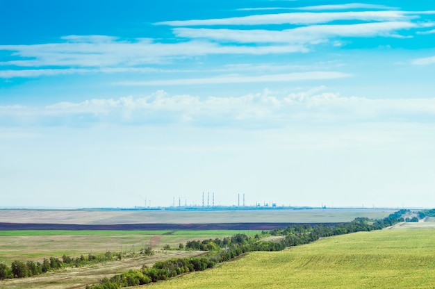 Landschap met landbouwgrond en industriële voorzieningen aan de horizon