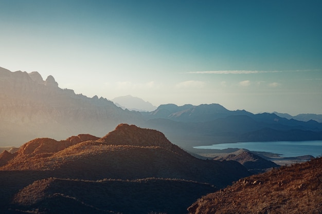 Landschap met opkomende zon boven bergen en een baai bij Loreto, Baja California, Mexico