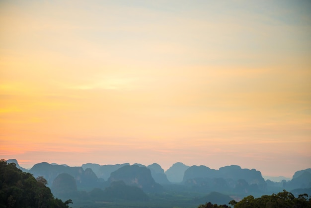 Landschap met prachtige dramatische zonsondergang en silhouet van blauwe bergen aan de horizon, Thailand