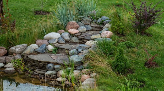 Landschap met tuinvijver met planten op het platteland. Architectuur van het platteland.