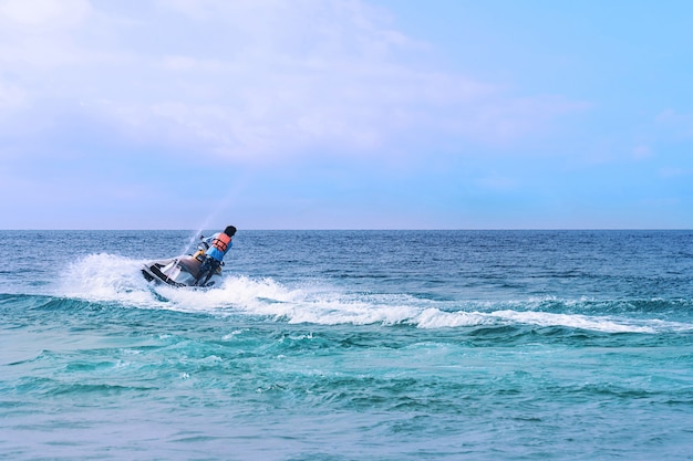 Landschap met uitzicht op het deel van de oude stad Sozopol, omringd door de zee. Er is een jetski en vakantiegangers in de zee. Bulgarije, de kust van de Zwarte Zee.