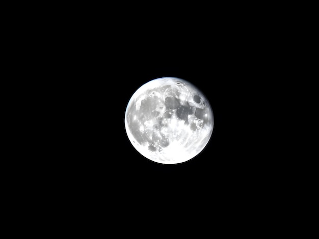Landschap opname van een witte volle maan met zwarte kleur op de achtergrond