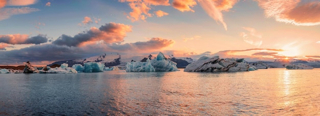 Landschap van de Jokulsarlon-gletsjerlagune met het smelten van blauwe ijsbergen en zonsonderganghemel op de zomer