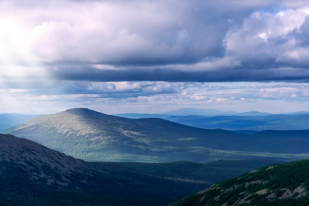 Landschap van de noordelijke bergen met prachtige zonnestralen die zich een weg banen van achter de wolken