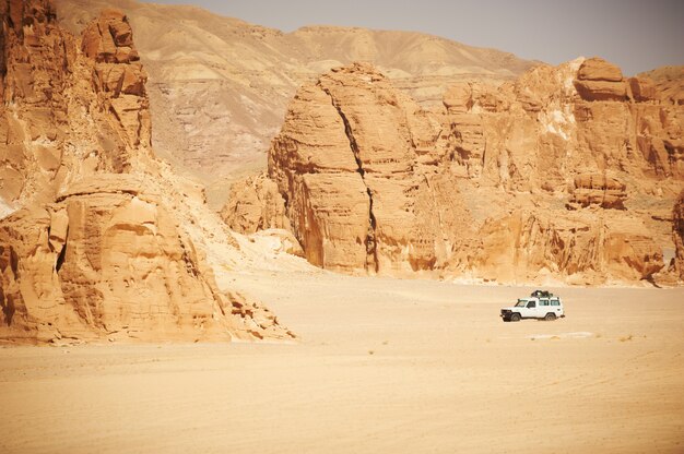 Landschap van de Sinaï-woestijn met rotsen en jeep voor safari.